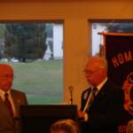 Lions Steve presents the Banner to DG Jim